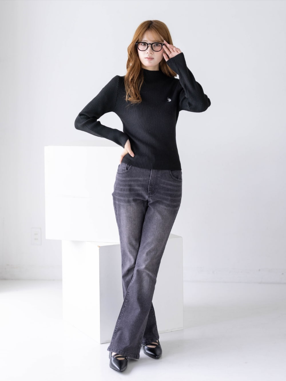 ブラック系のデニムパンツ、ブラック系のパンプス、ブラック系のニット/セーターを着用したレディースの秋コーディネートの3枚目の写真