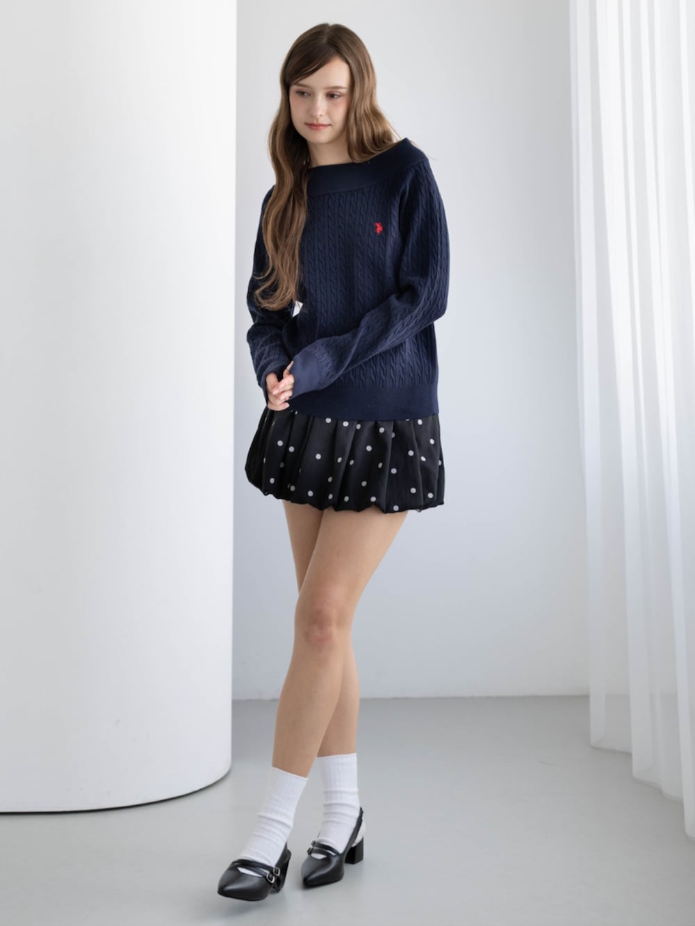 ブラック系のパンプス、ブルー系のニット/セーター、ブラック系のスカートを着用したレディースの秋コーディネートの3枚目の写真