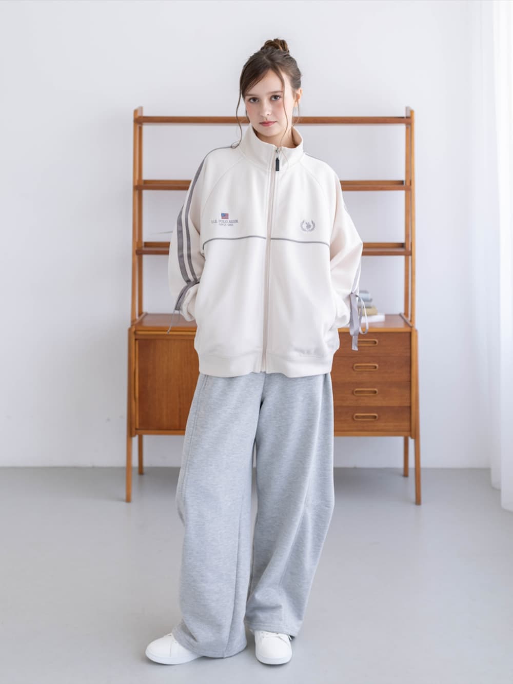 ゴールド系のスニーカー、グレー系のスウェットパンツ、ホワイト系のTシャツ/カットソーを着用したレディースの秋コーディネートの2枚目の写真