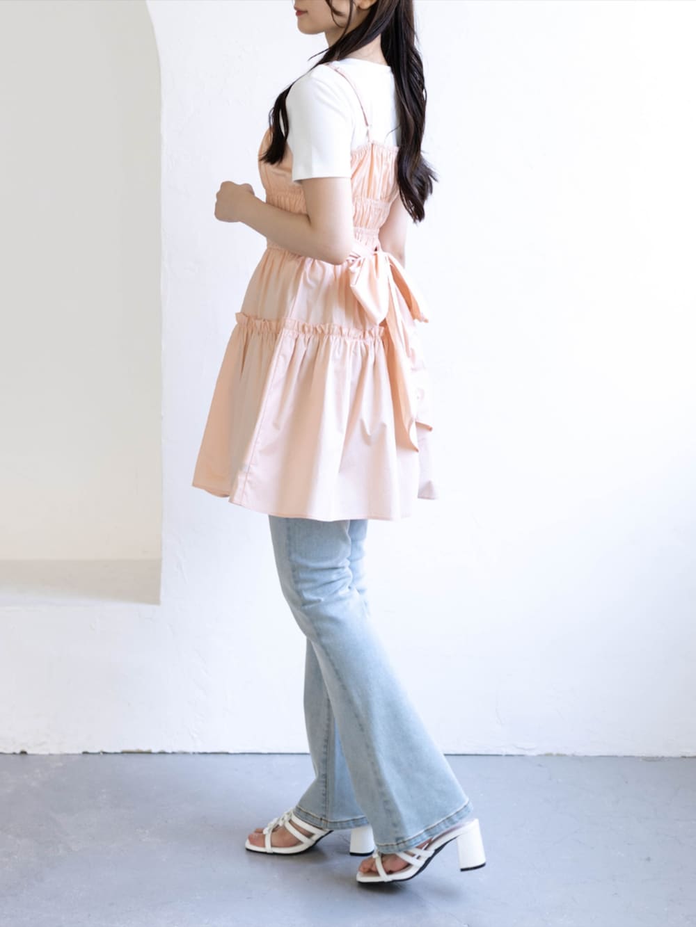 ブルー系のデニムパンツ、ホワイト系のサンダル、ピンク系のワンピースを着用したレディースの夏コーディネートの5枚目の写真