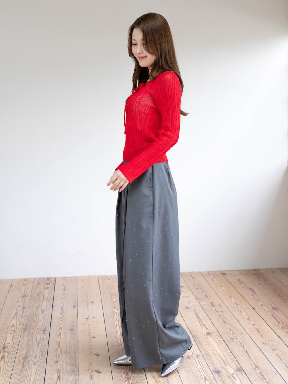 シルバー系のパンプス、レッド系のニット/セーター、グレー系のその他パンツを着用したレディースの春コーディネートの3枚目の写真