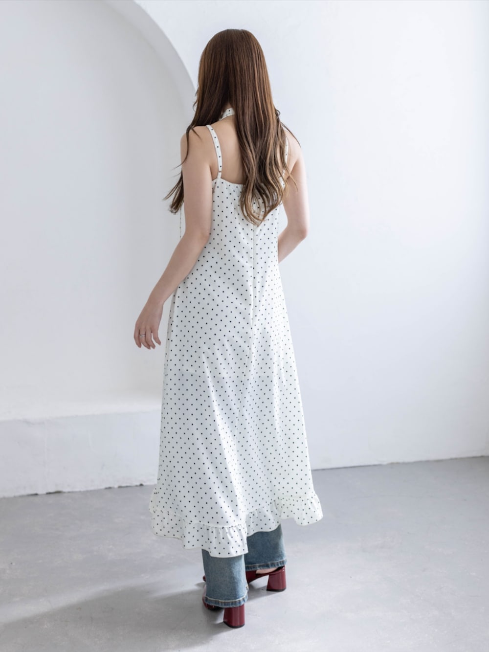 レッド系のパンプス、ブルー系のデニムパンツ、ホワイト系のワンピースを着用したレディースの夏コーディネートの5枚目の写真