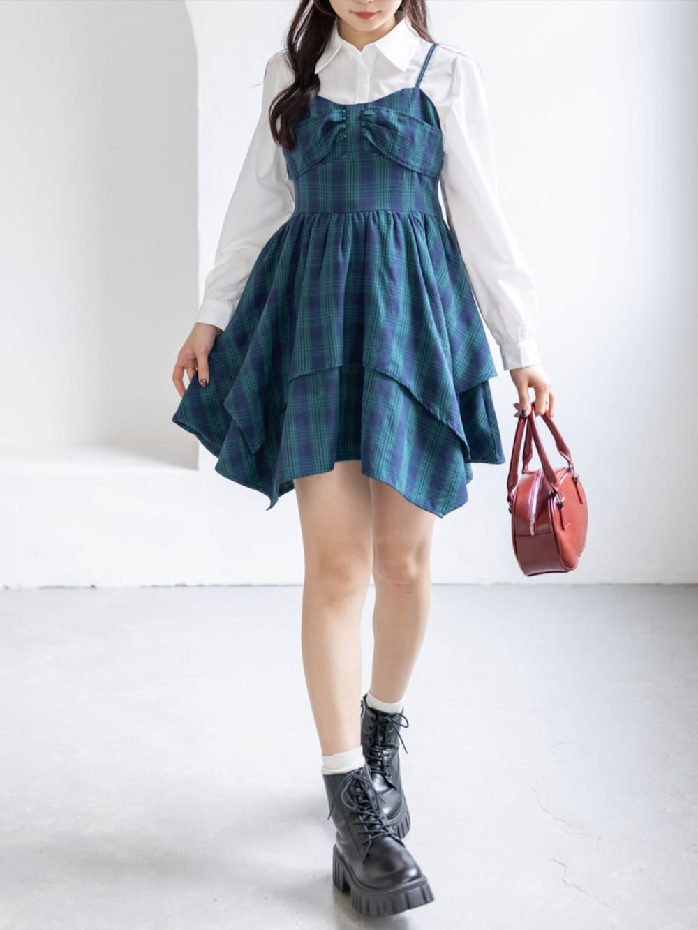 グリーン系のワンピース、ブラック系のブーツ、ホワイト系のシャツ/ブラウスを着用したレディースの春コーディネートの2枚目の写真