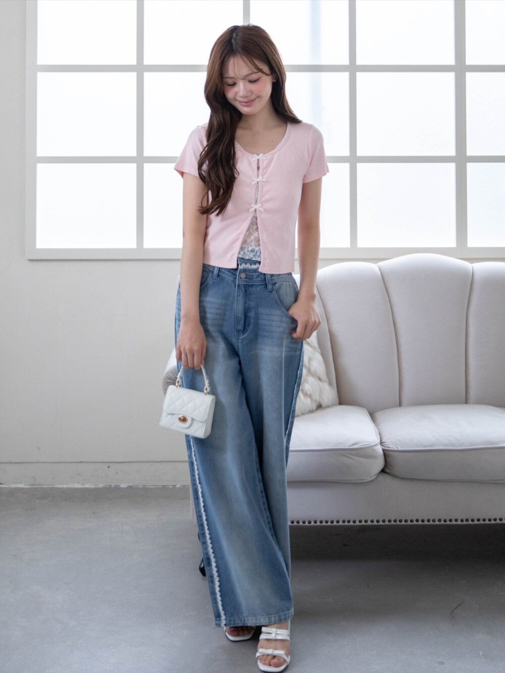 ブルー系のデニムパンツ、ピンク系のTシャツ/カットソー、ホワイト系のサンダルを着用したレディースの春コーディネートの2枚目の写真