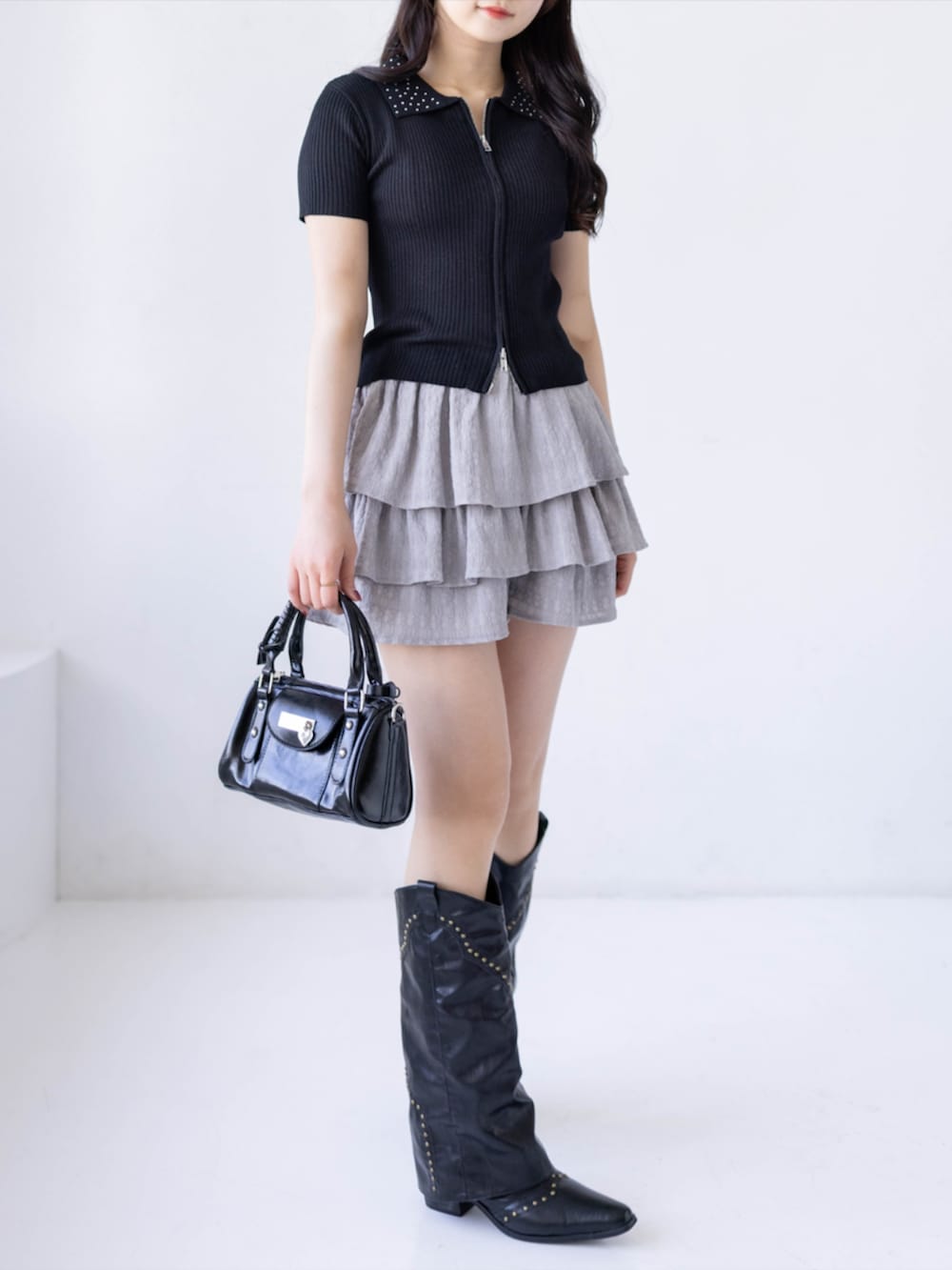 ブラック系のブーツ、ブラック系のハンドバッグ、グレー系のその他パンツを着用したレディースの夏コーディネートの3枚目の写真