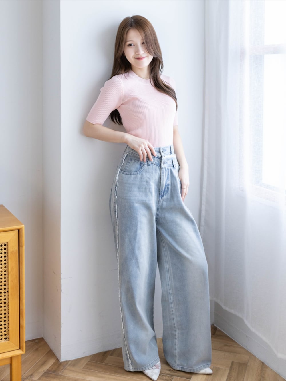 ピンク系のニット/セーター、ブルー系のデニムパンツ、ホワイト系のパンプスを着用したレディースの夏コーディネートの2枚目の写真