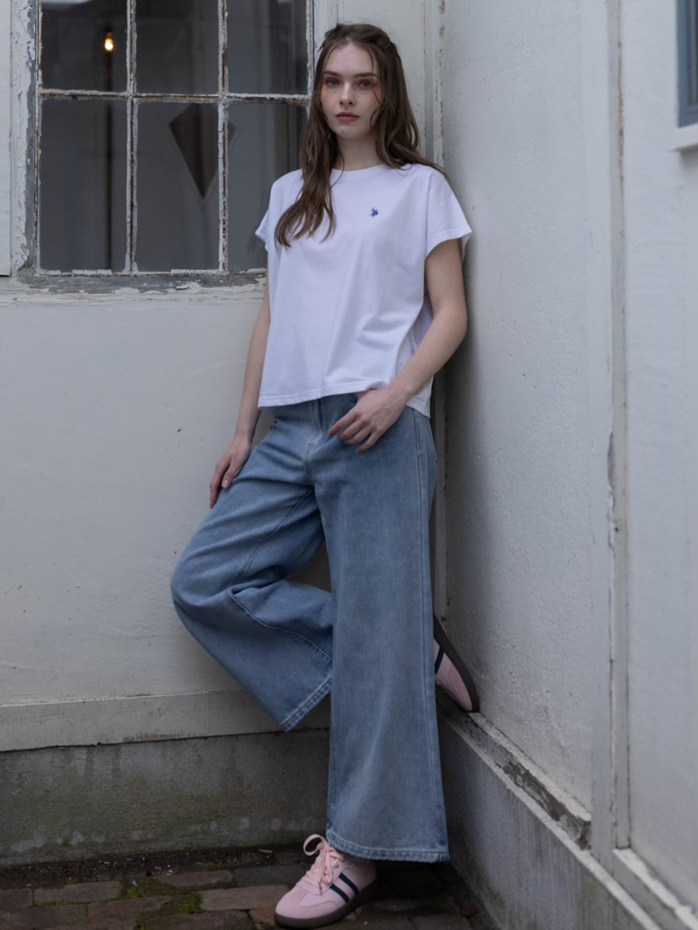ブルー系のデニムパンツ、ホワイト系のTシャツ/カットソー、ピンク系のスニーカーを着用したレディースの夏コーディネートの2枚目の写真