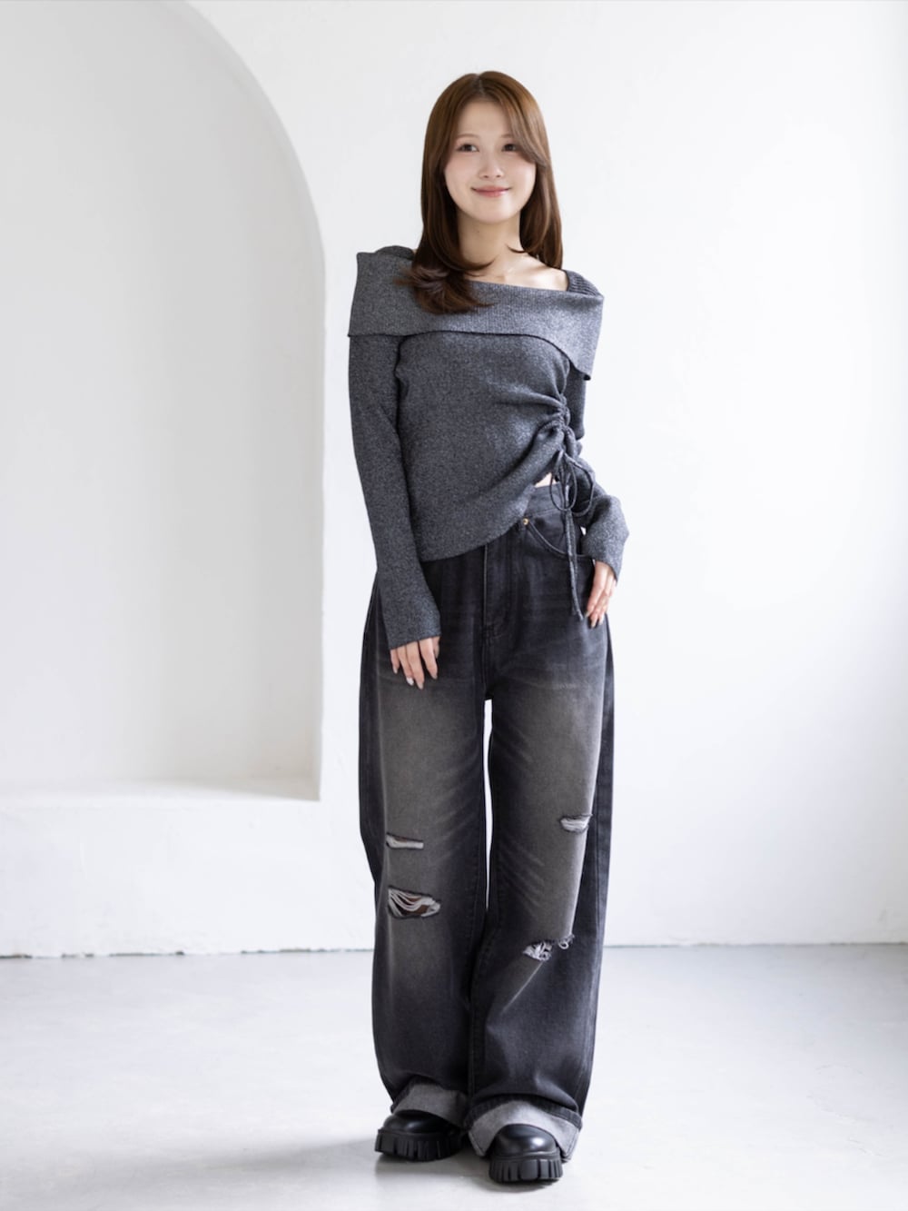 ブラック系のデニムパンツ、ブラック系のブーツ、ブラック系のニット/セーターを着用したレディースの秋コーディネートの2枚目の写真