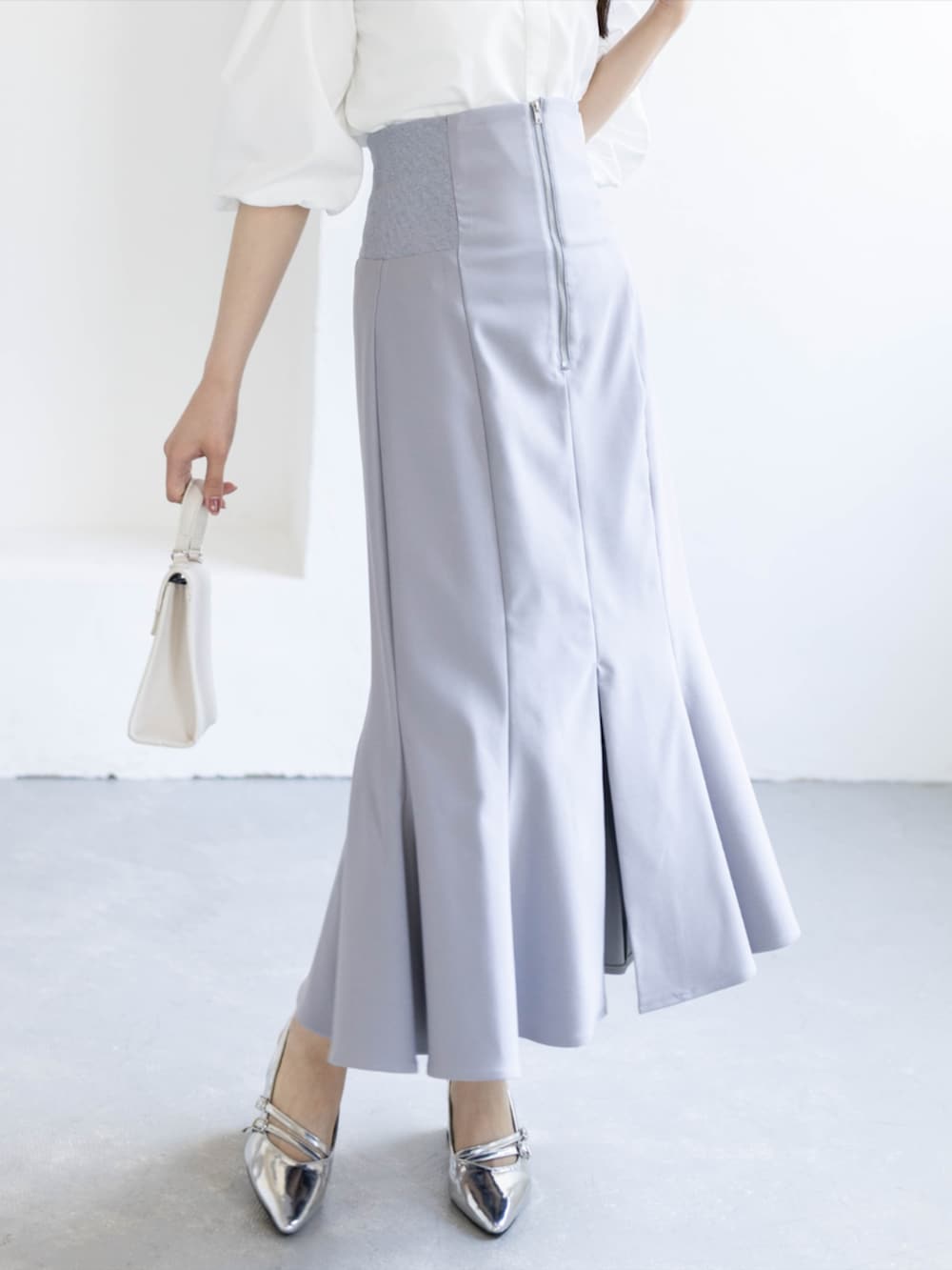 シルバー系のパンプス、ホワイト系のシャツ/ブラウス、グレー系のスカートを着用したレディースの夏コーディネートの5枚目の写真