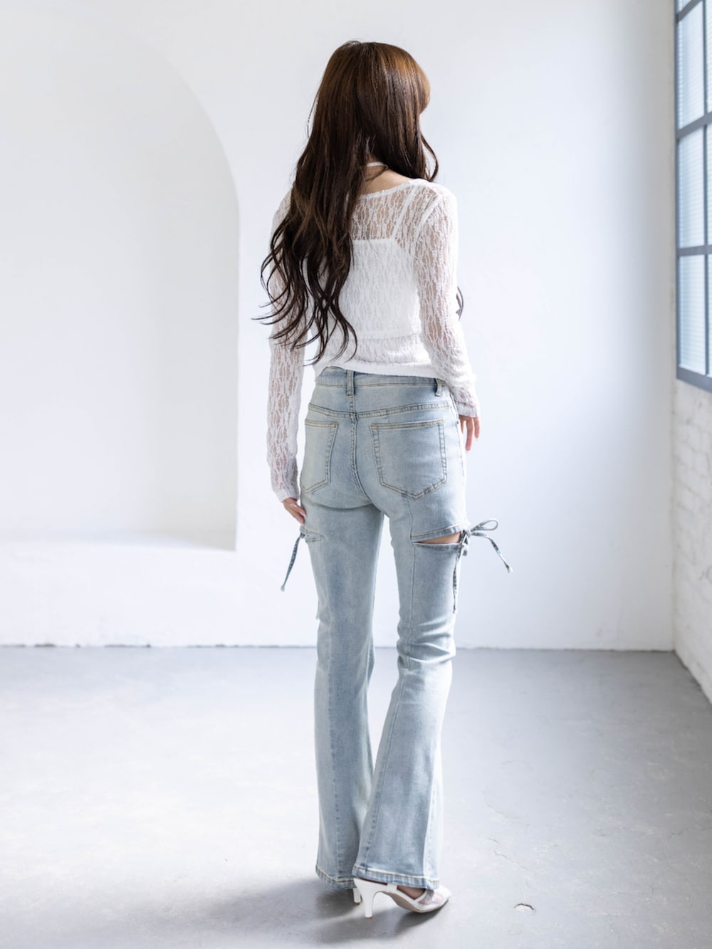 ホワイト系のパンプス、ホワイト系のカーディガン/ボレロ、ブルー系のデニムパンツを着用したレディースの春コーディネートの3枚目の写真