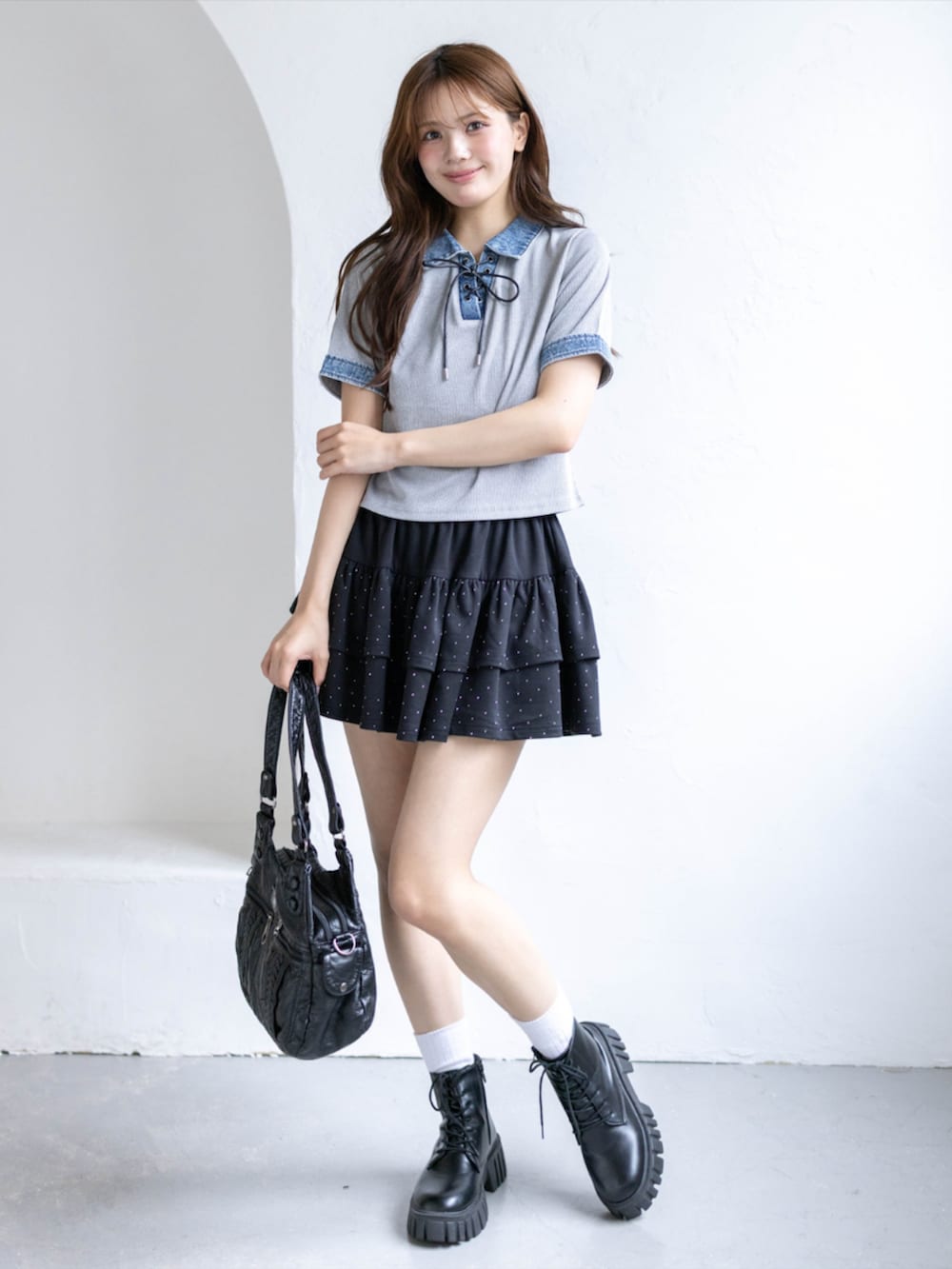 ブラック系のブーツ、ブラック系のスカート、グレー系のTシャツ/カットソーを着用したレディースの春コーディネートの2枚目の写真