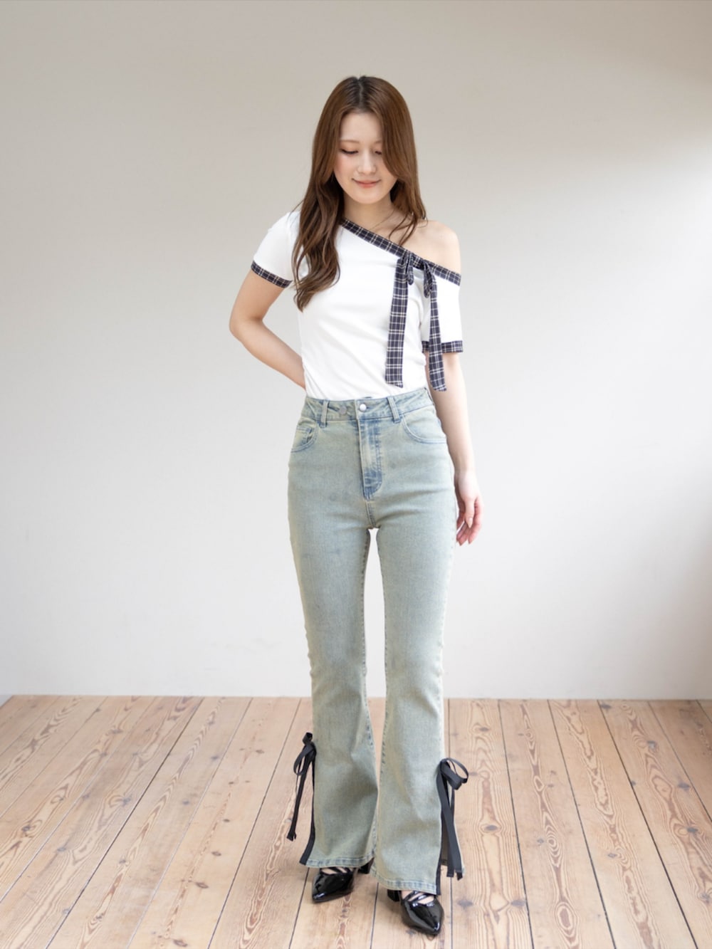 ブラック系のパンプス、ホワイト系のTシャツ/カットソー、ブルー系のデニムパンツを着用したレディースの夏コーディネートの3枚目の写真