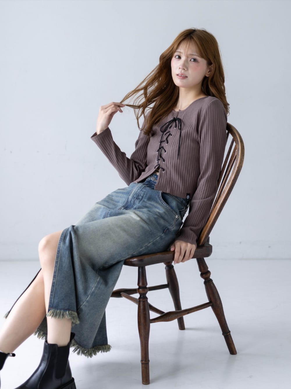 ブルー系のデニムスカート、ブラウン系のTシャツ/カットソー、ブラック系のブーツを着用したレディースの秋コーディネートの7枚目の写真