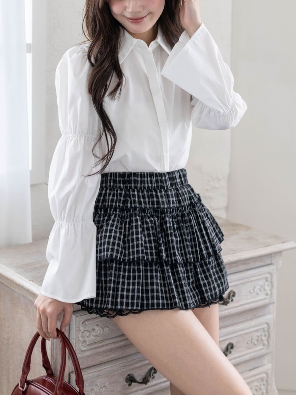 ホワイト系のシャツ/ブラウス、ブラック系のブーツ、ブラック系のスカートを着用したレディースの春コーディネートの3枚目の写真