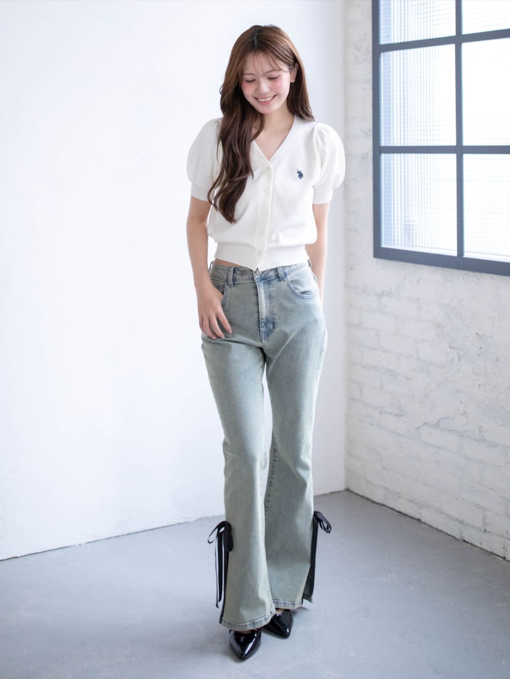 ブラック系のパンプス、ブルー系のデニムパンツ、ホワイト系のニット/セーターを着用したレディースの夏コーディネートの3枚目の写真