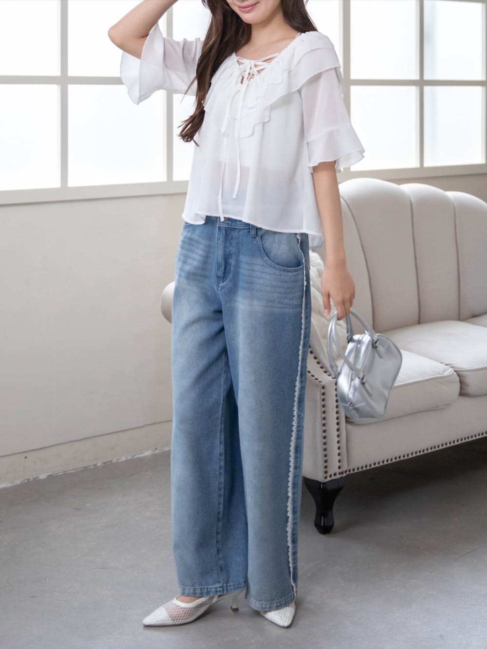 ホワイト系のパンプス、ブルー系のデニムパンツ、ホワイト系のシャツ/ブラウスを着用したレディースの夏コーディネートの2枚目の写真