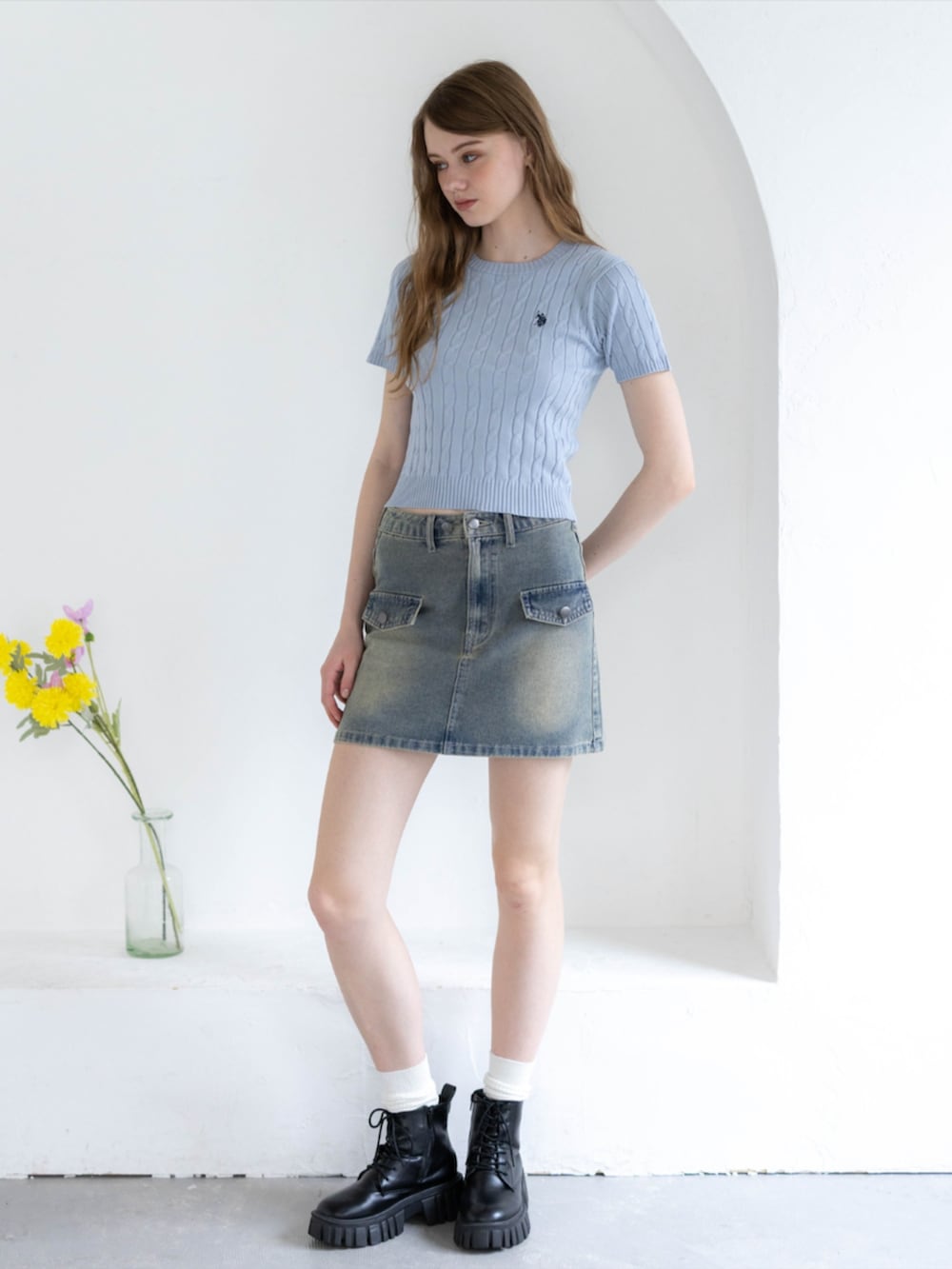 ブラック系のブーツ、ブルー系のデニムスカート、グレー系のニット/セーターを着用したレディースの夏コーディネートの2枚目の写真