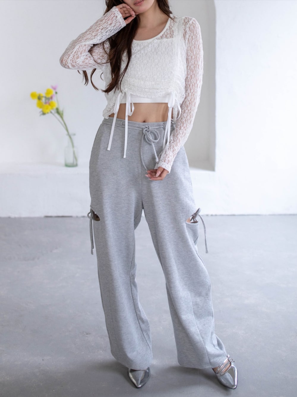 シルバー系のパンプス、ホワイト系のTシャツ/カットソー、グレー系のスウェットパンツを着用したレディースの春コーディネートの2枚目の写真