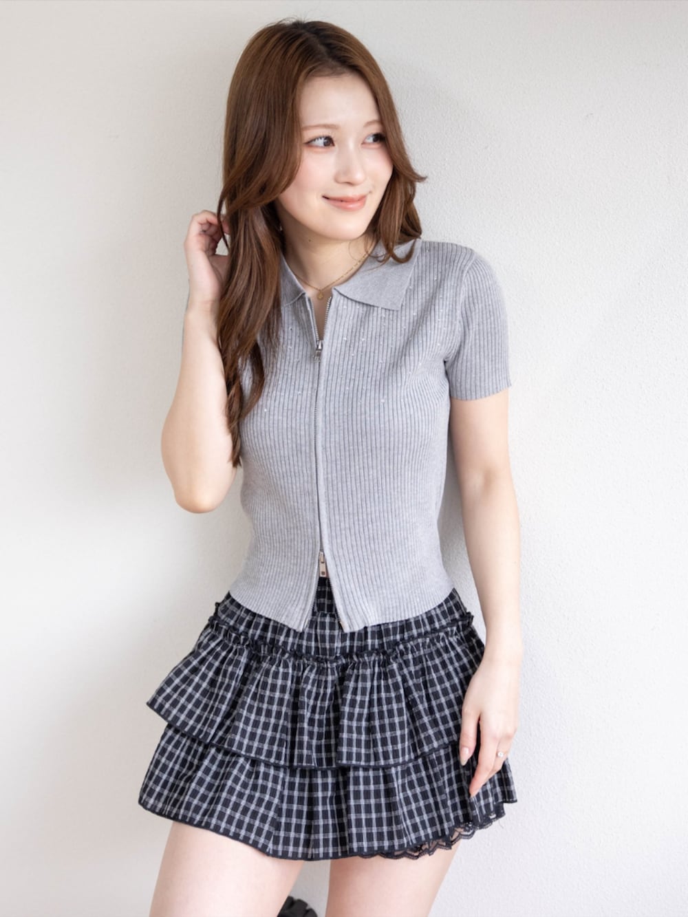 ブラック系のブーツ、ブラック系のスカート、グレー系のニット/セーターを着用したレディースの春コーディネートの3枚目の写真