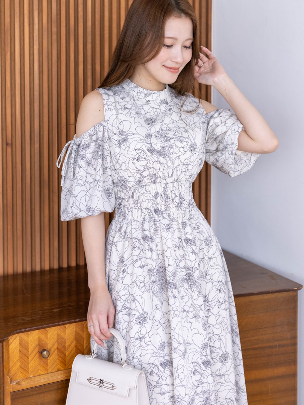 ホワイト系のワンピース、ホワイト系のハンドバッグを着用したレディースの冬コーディネートの4枚目の写真