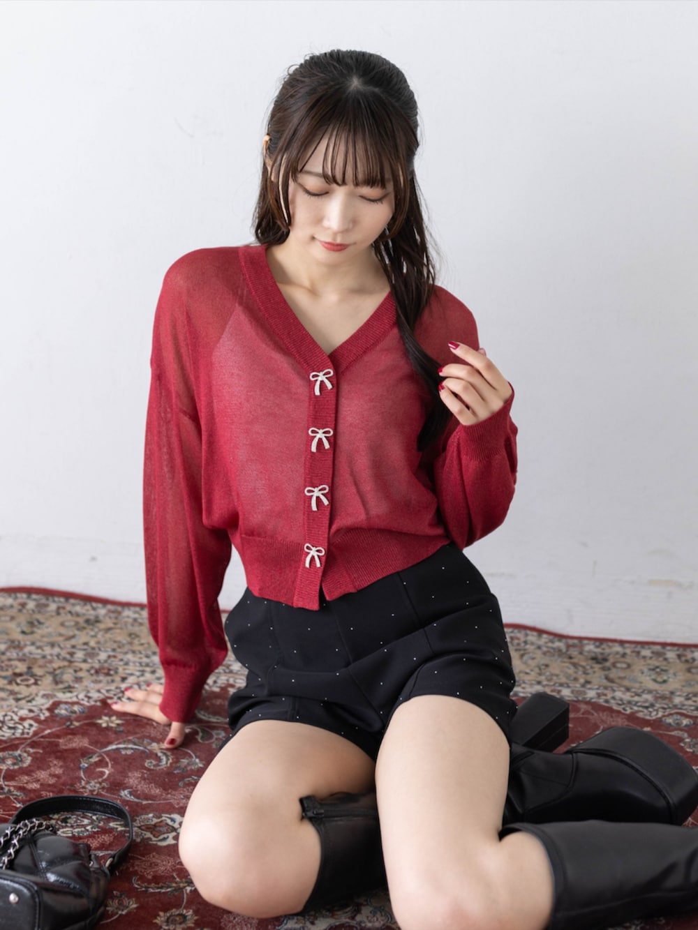 ブラック系のその他パンツ、ブラック系のブーツ、レッド系のカーディガン/ボレロを着用したレディースの秋コーディネートの7枚目の写真
