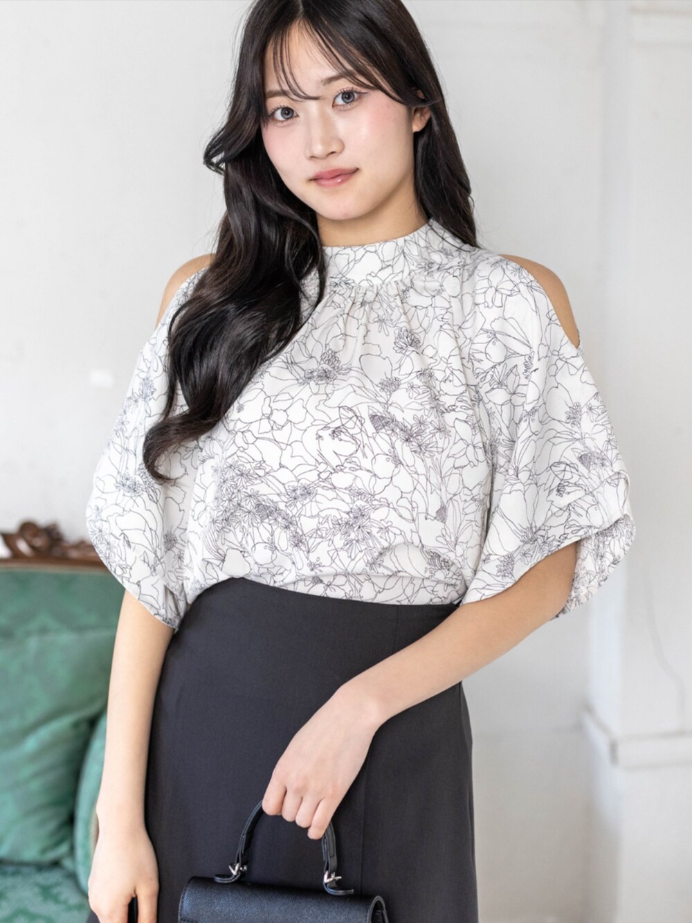 ブラック系のハンドバッグ、ブラック系のパンプス、ブラック系のスカートを着用したレディースの春コーディネートの3枚目の写真