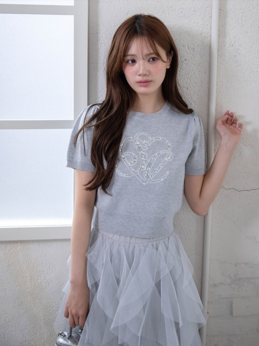 ホワイト系のパンプス、グレー系のスカート、グレー系のニット/セーターを着用したレディースの春コーディネートの4枚目の写真