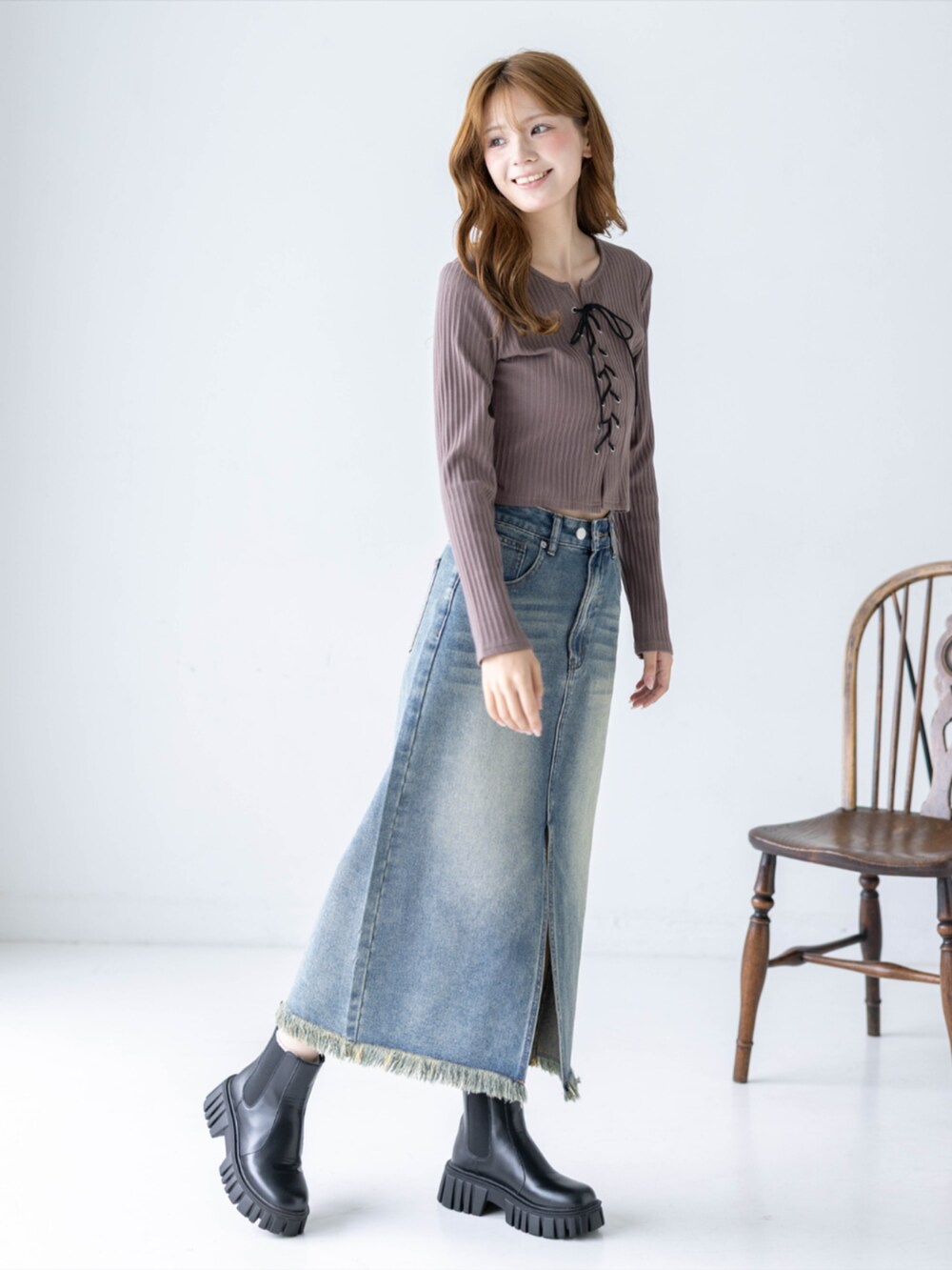 ブルー系のデニムスカート、ブラウン系のTシャツ/カットソー、ブラック系のブーツを着用したレディースの秋コーディネートの4枚目の写真