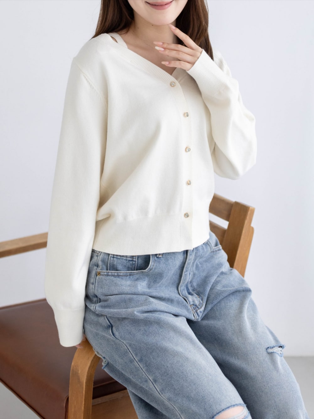 シルバー系のパンプス、ブルー系のデニムパンツ、ホワイト系のカーディガン/ボレロを着用したレディースの秋コーディネートの6枚目の写真