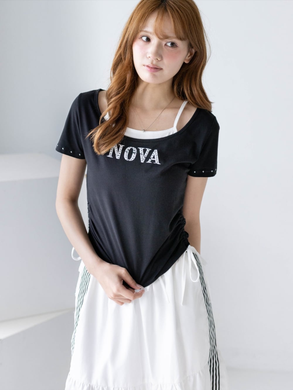 ブラック系のブーツ、ホワイト系のスカート、ブラック系のTシャツ/カットソーを着用したレディースの夏コーディネートの5枚目の写真