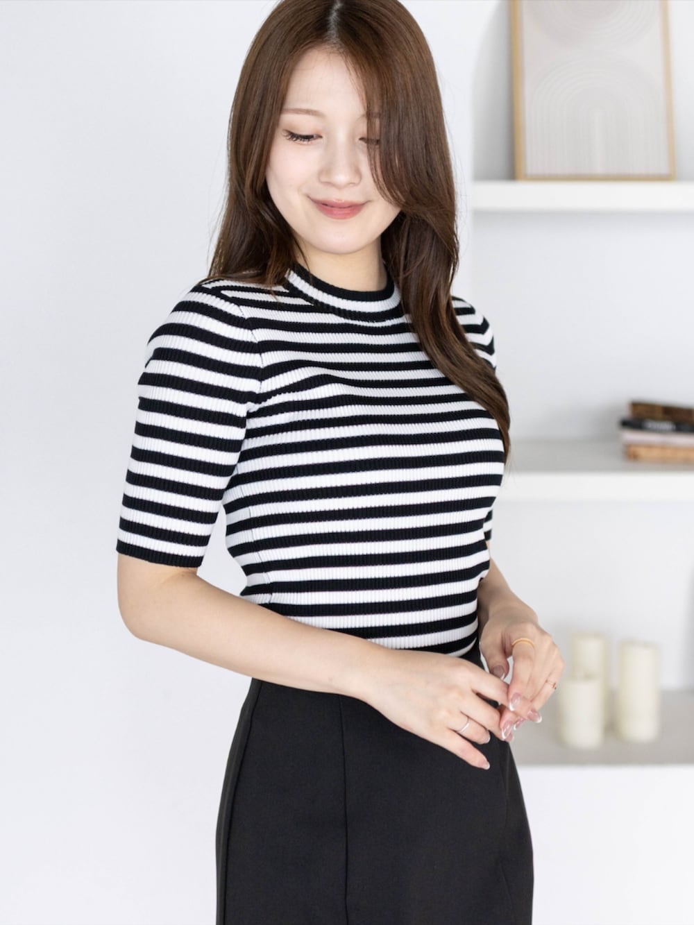 ブラック系のニット/セーター、ブラック系のパンプス、ブラック系のスカートを着用したレディースの夏コーディネートの4枚目の写真