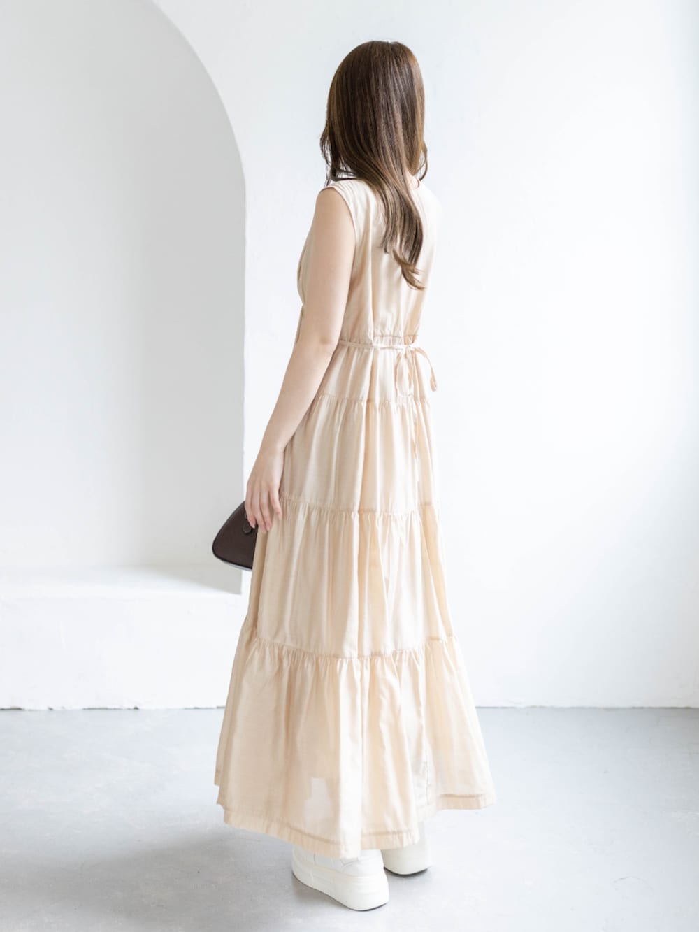 ベージュ系のワンピースを着用したレディースの春コーディネートの3枚目の写真