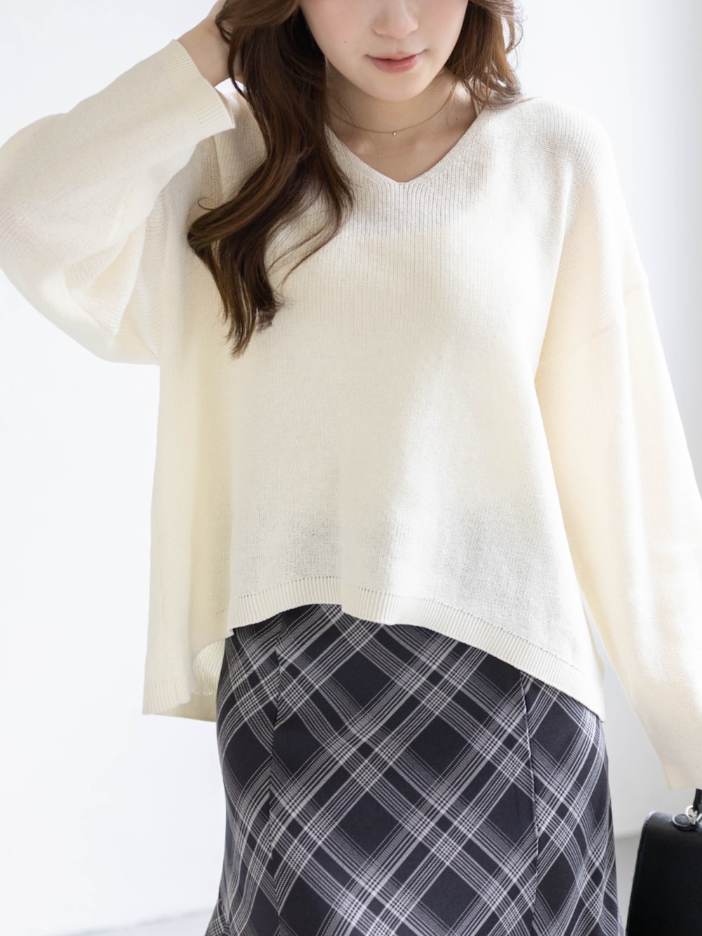 ブラック系のパンプス、ホワイト系のニット/セーター、ブラック系のスカートを着用したレディースの春コーディネートの5枚目の写真