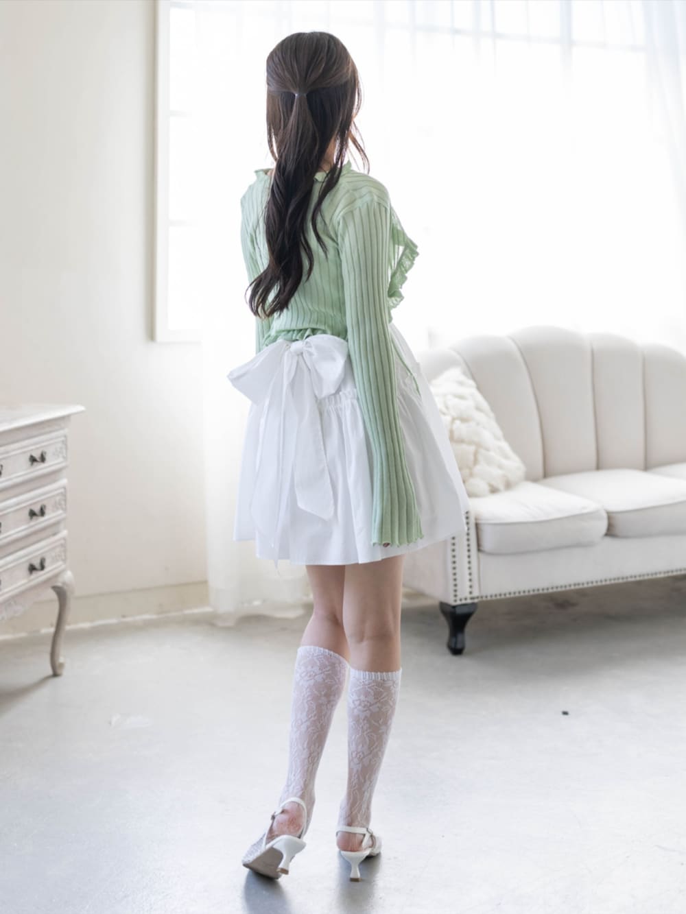 ホワイト系のパンプス、グリーン系のカーディガン/ボレロ、ホワイト系のワンピースを着用したレディースの夏コーディネートの3枚目の写真