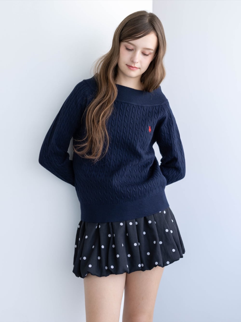 ブラック系のパンプス、ブルー系のニット/セーター、ブラック系のスカートを着用したレディースの秋コーディネートの6枚目の写真