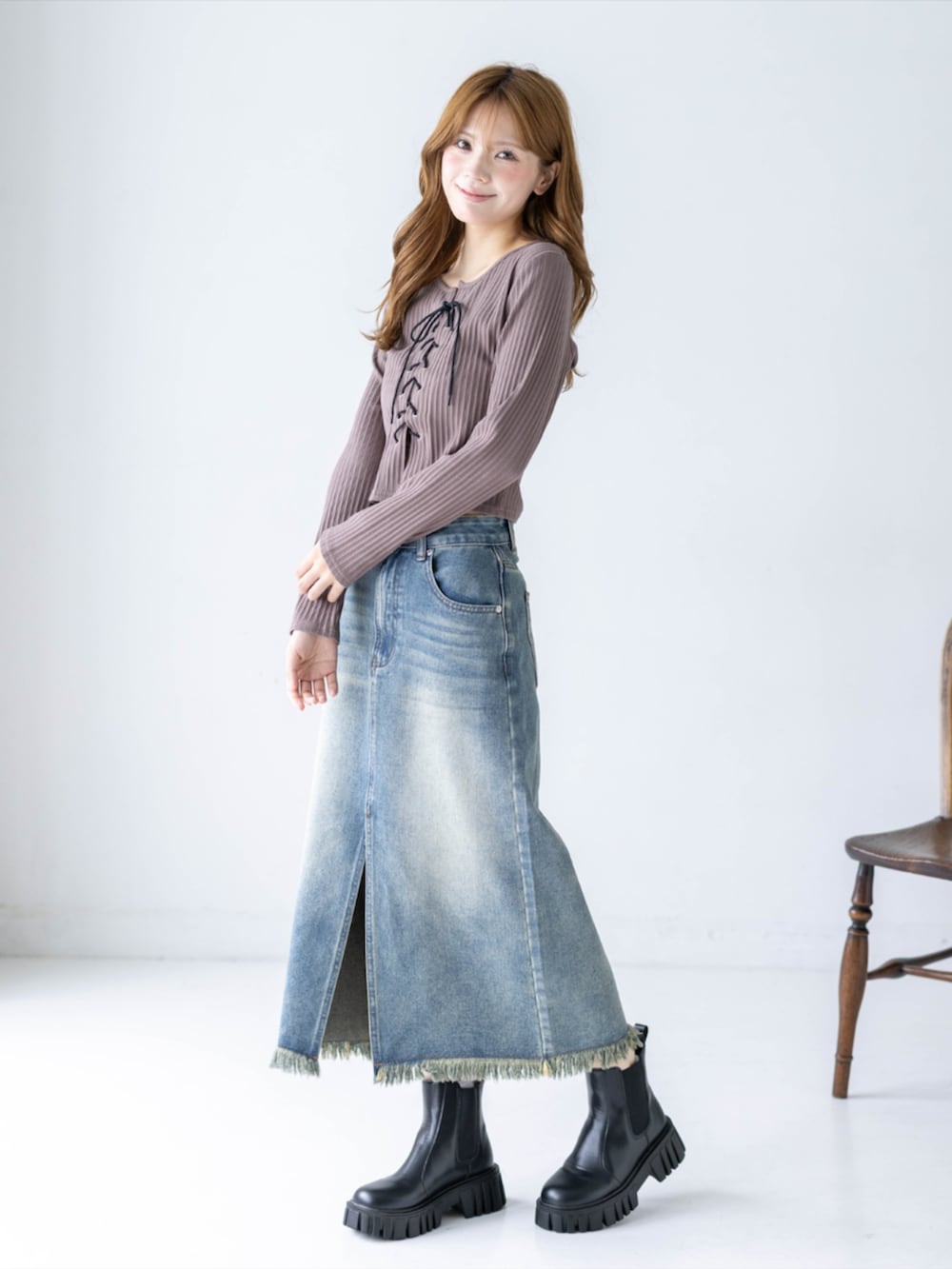 ブルー系のデニムスカート、ブラウン系のTシャツ/カットソー、ブラック系のブーツを着用したレディースの秋コーディネートの2枚目の写真