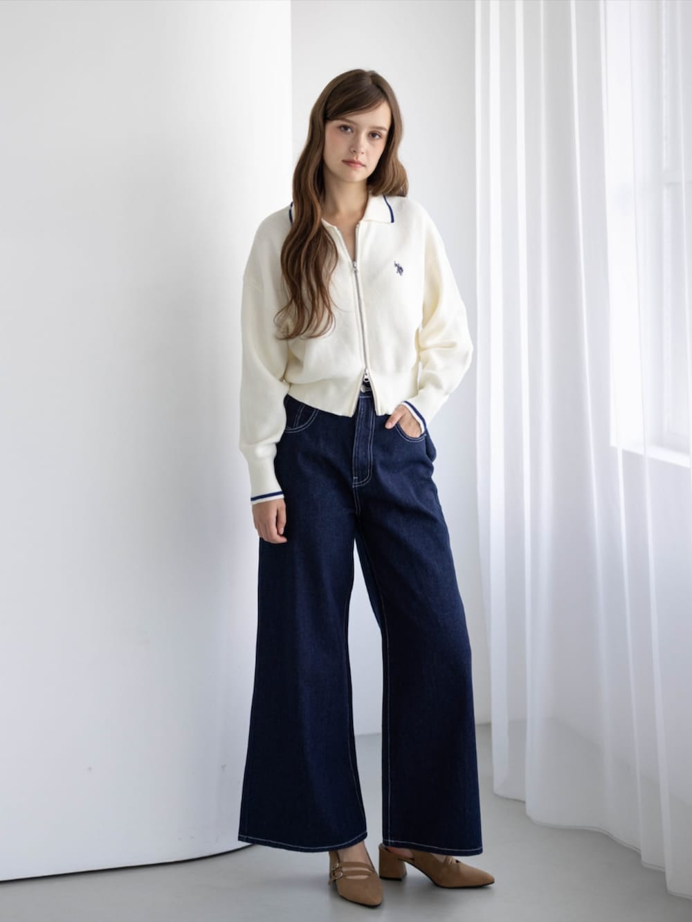 ゴールド系のスニーカー、ブルー系のデニムパンツ、ホワイト系のTシャツ/カットソーを着用したレディースの秋コーディネートの3枚目の写真
