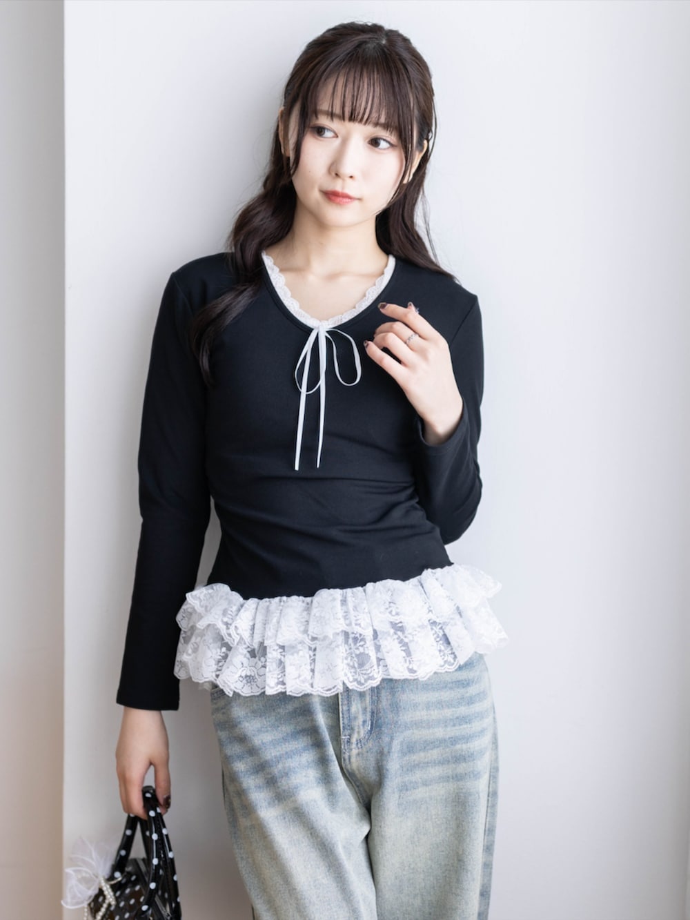 ブラック系のパンプス、ブラック系のボストンバッグ、ブルー系のデニムパンツを着用したレディースの夏コーディネートの6枚目の写真