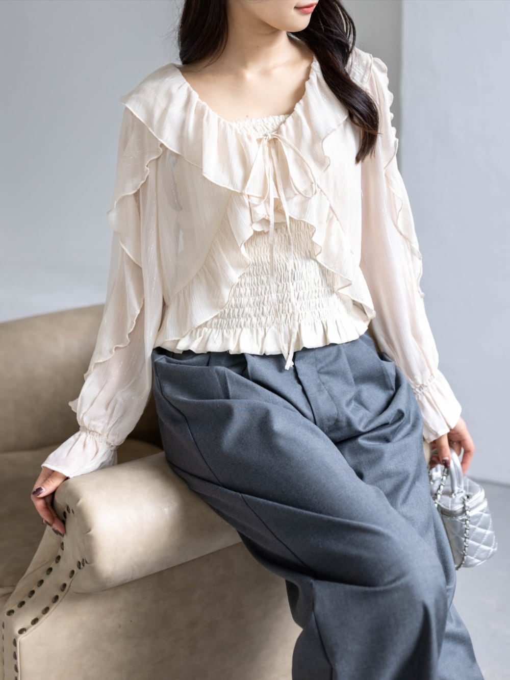 シルバー系のパンプス、ブラック系のスラックス、ベージュ系のシャツ/ブラウスを着用したレディースの春コーディネートの5枚目の写真