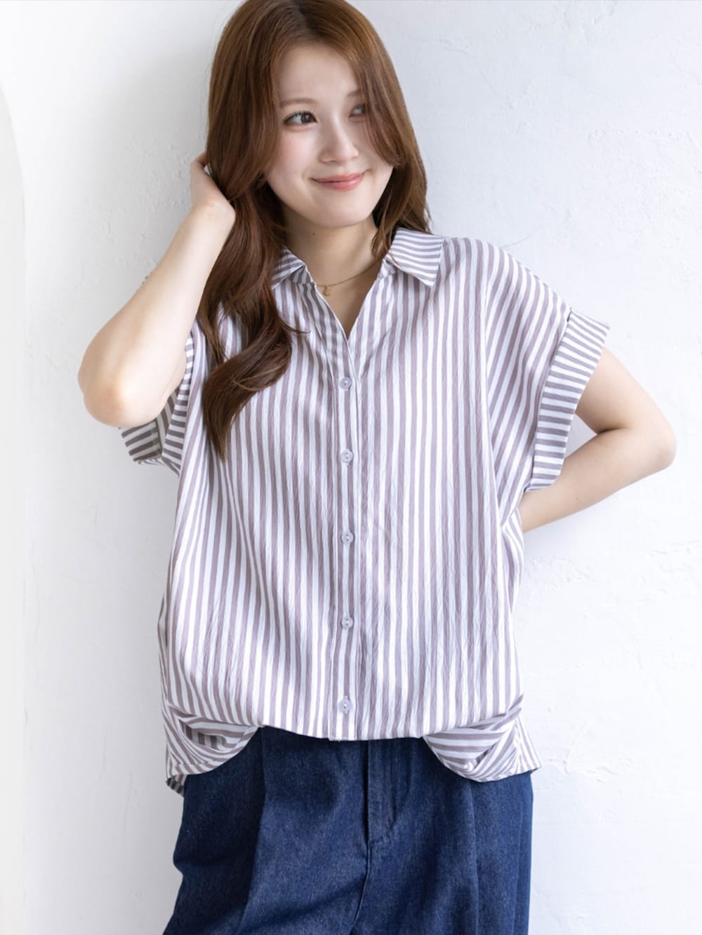 シルバー系のパンプス、ベージュ系のシャツ/ブラウス、ブルー系のデニムパンツを着用したレディースの夏コーディネートの4枚目の写真