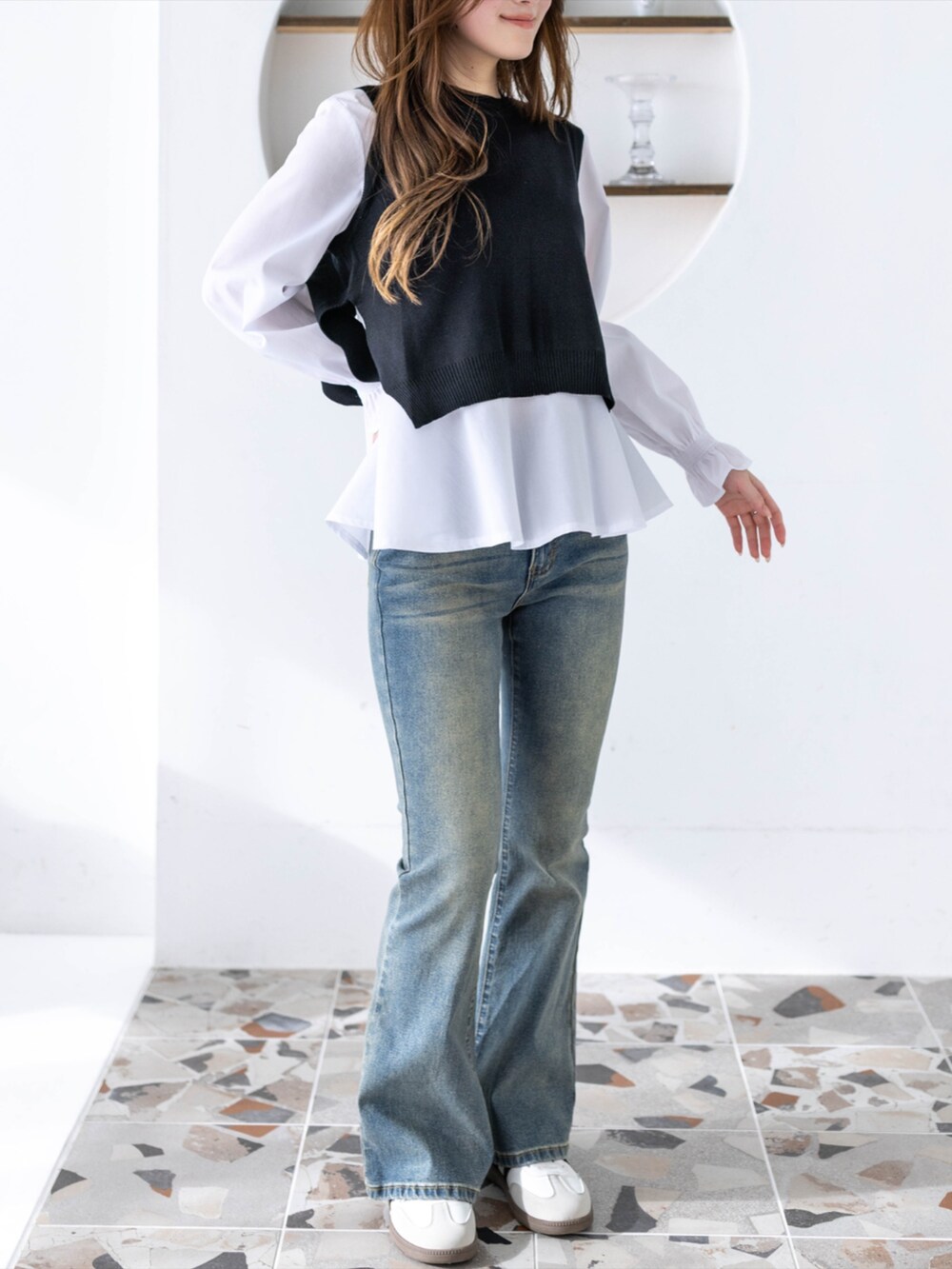 ブルー系のデニムパンツ、ホワイト系のスニーカー、ブラック系のシャツ/ブラウスを着用したレディースの冬コーディネートの3枚目の写真