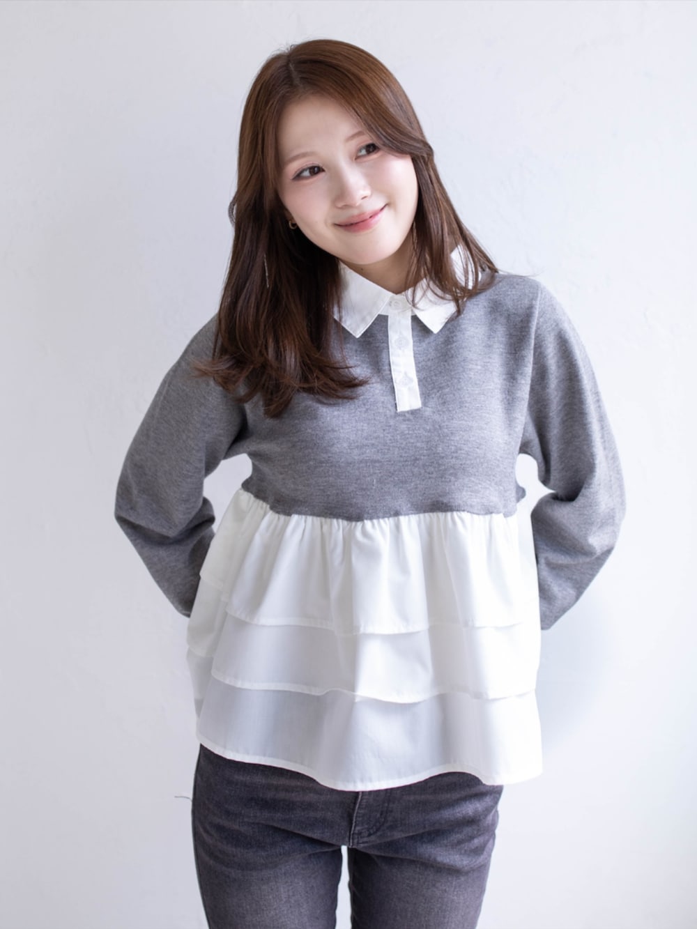 ブラック系のデニムパンツ、ブラック系のパンプス、グレー系のニット/セーターを着用したレディースの秋コーディネートの4枚目の写真