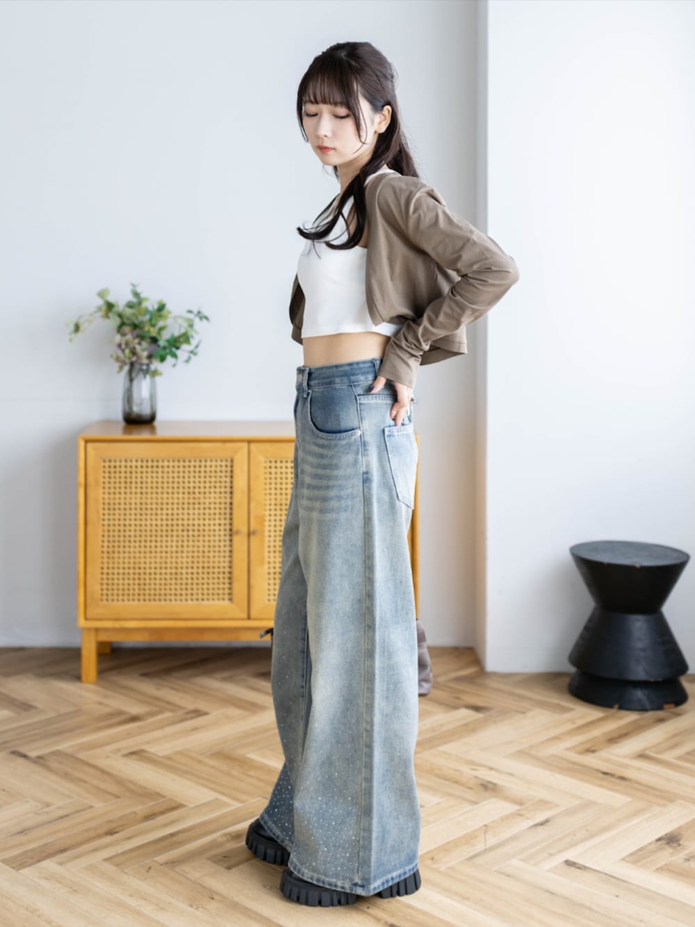 ブラウン系のショルダーバッグ、ブルー系のデニムパンツ、ブラウン系のカーディガン/ボレロを着用したレディースの夏コーディネートの3枚目の写真