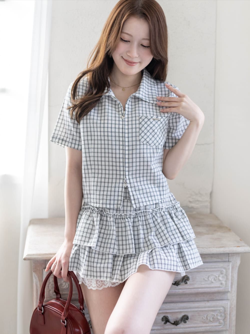 レッド系のパンプス、ホワイト系のスカート、ホワイト系のシャツ/ブラウスを着用したレディースの春コーディネートの3枚目の写真