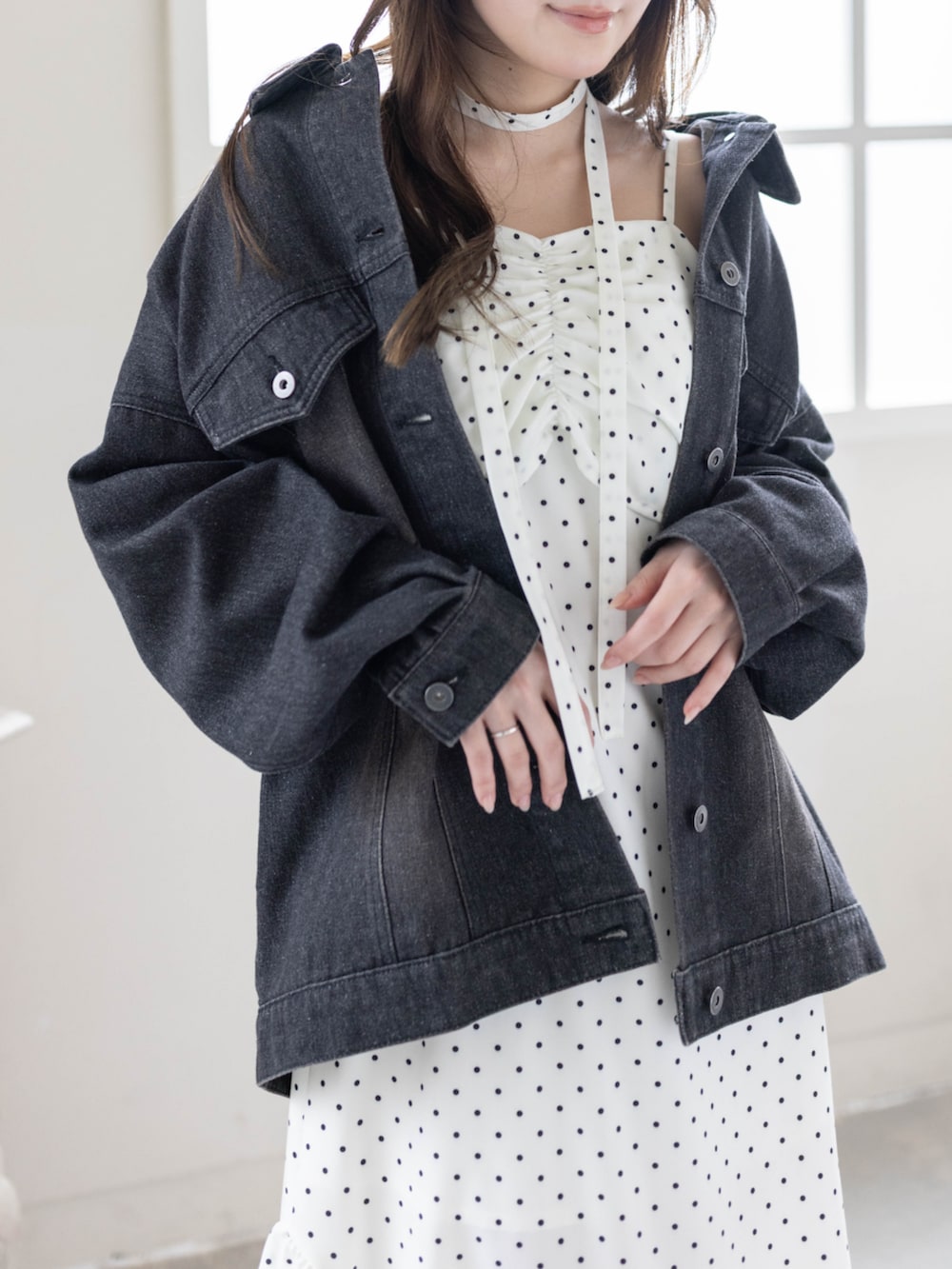 ブラック系のブーツ、ブラック系のデニムジャケット、ホワイト系のワンピースを着用したレディースの春コーディネートの5枚目の写真