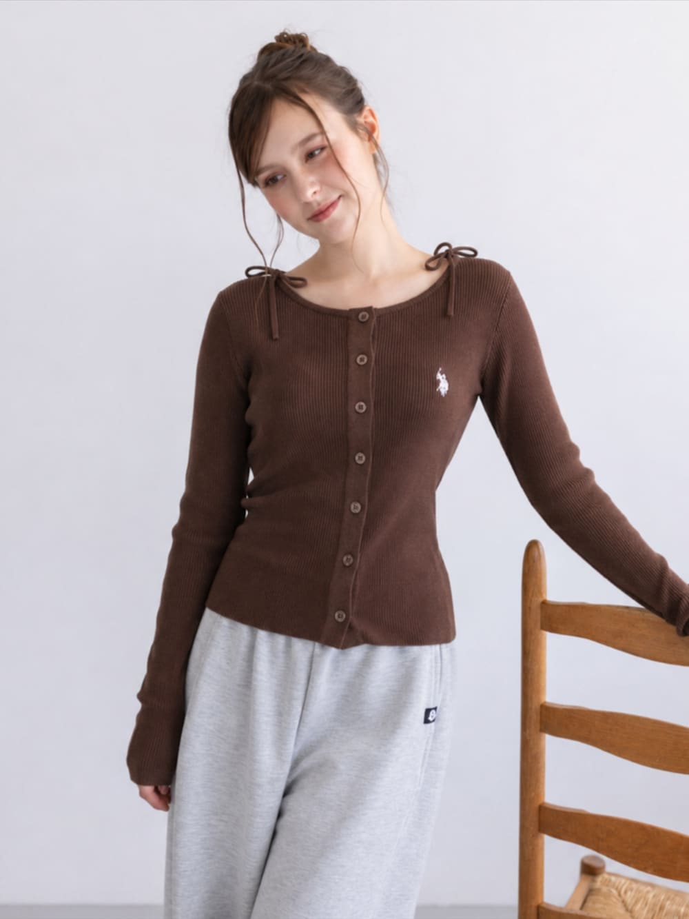 グレー系のスウェットパンツ、イエロー系のスニーカー、ブラウン系のニット/セーターを着用したレディースの秋コーディネートの2枚目の写真