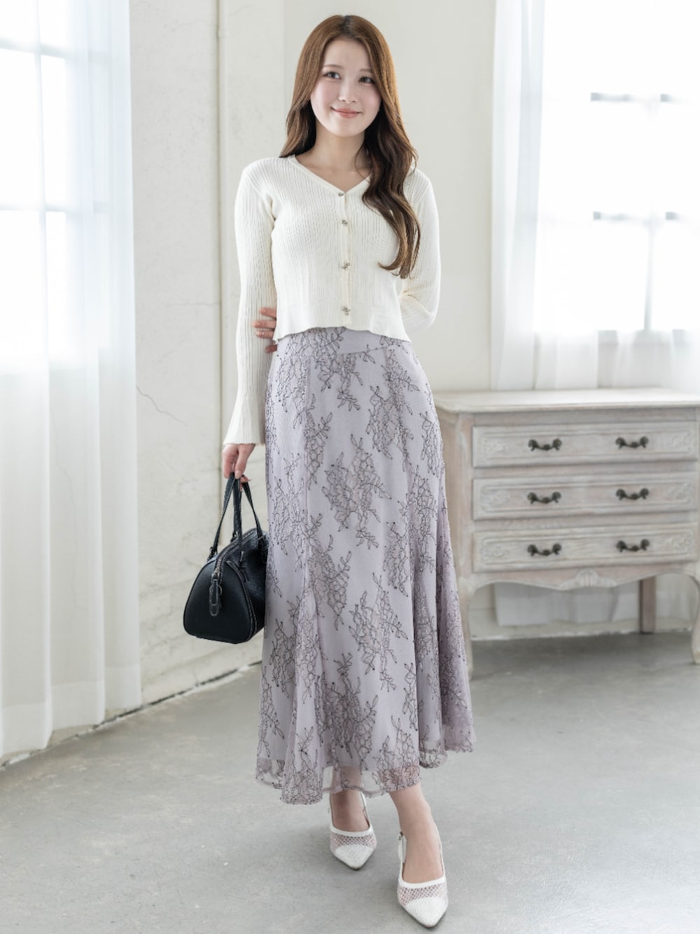 ホワイト系のカーディガン/ボレロ、グレー系のスカートを着用したレディースの冬コーディネートの3枚目の写真