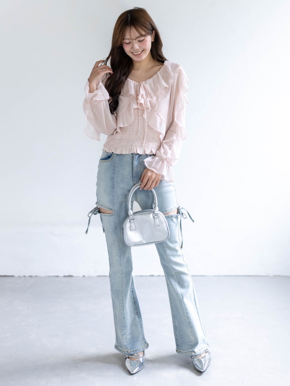 シルバー系のパンプス、ブルー系のデニムパンツ、ピンク系のシャツ/ブラウスを着用したレディースの春コーディネートの2枚目の写真