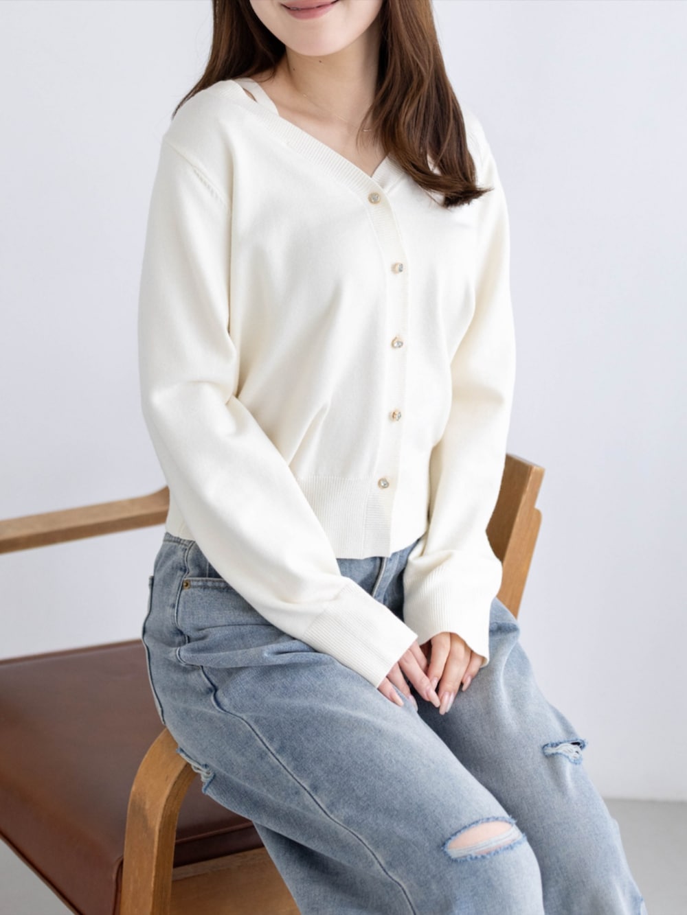 シルバー系のパンプス、ブルー系のデニムパンツ、ホワイト系のカーディガン/ボレロを着用したレディースの秋コーディネートの7枚目の写真