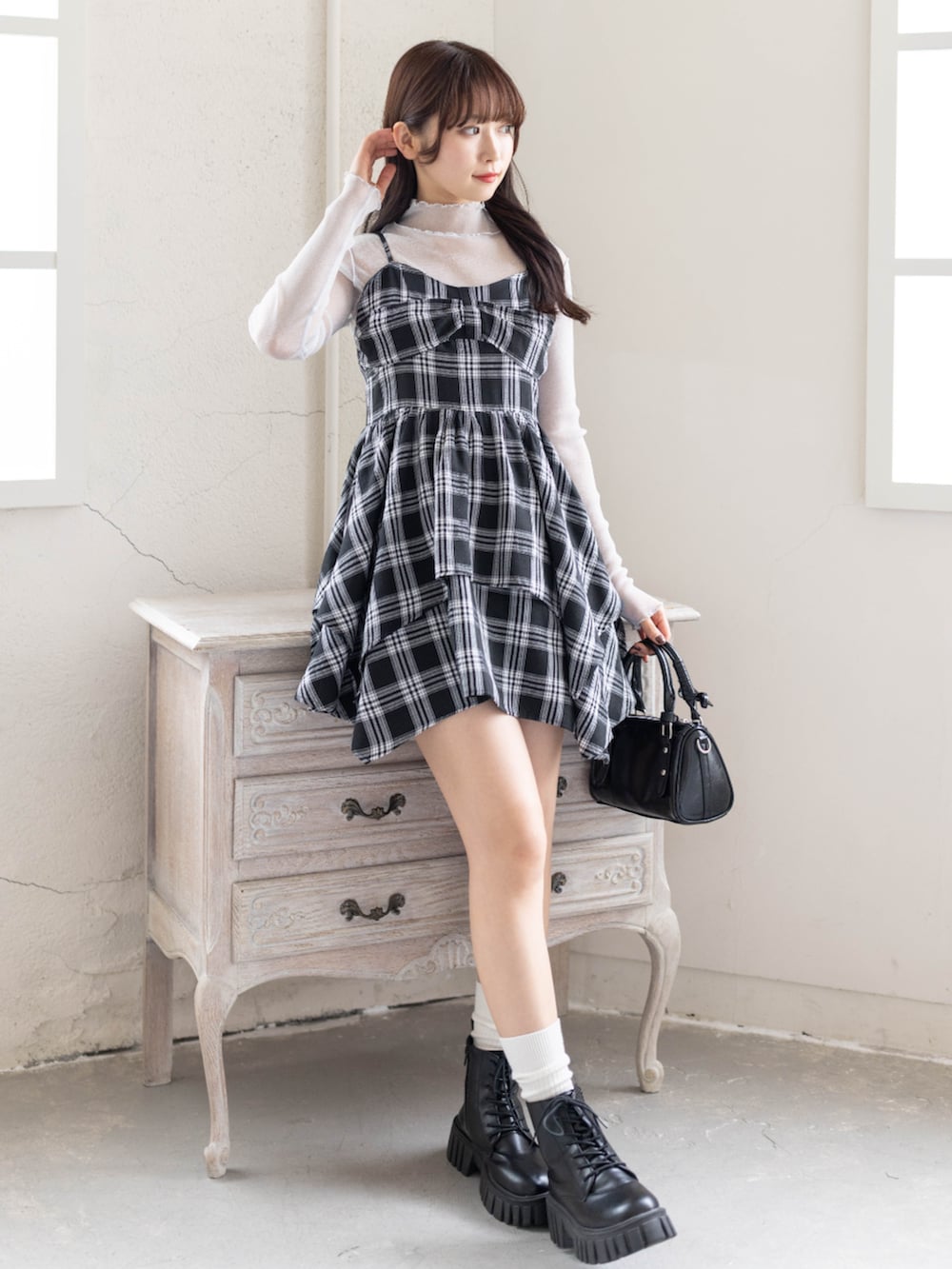 グレー系のTシャツ/カットソー、ブラック系のワンピース、ブラック系のブーツを着用したレディースの春コーディネートの2枚目の写真